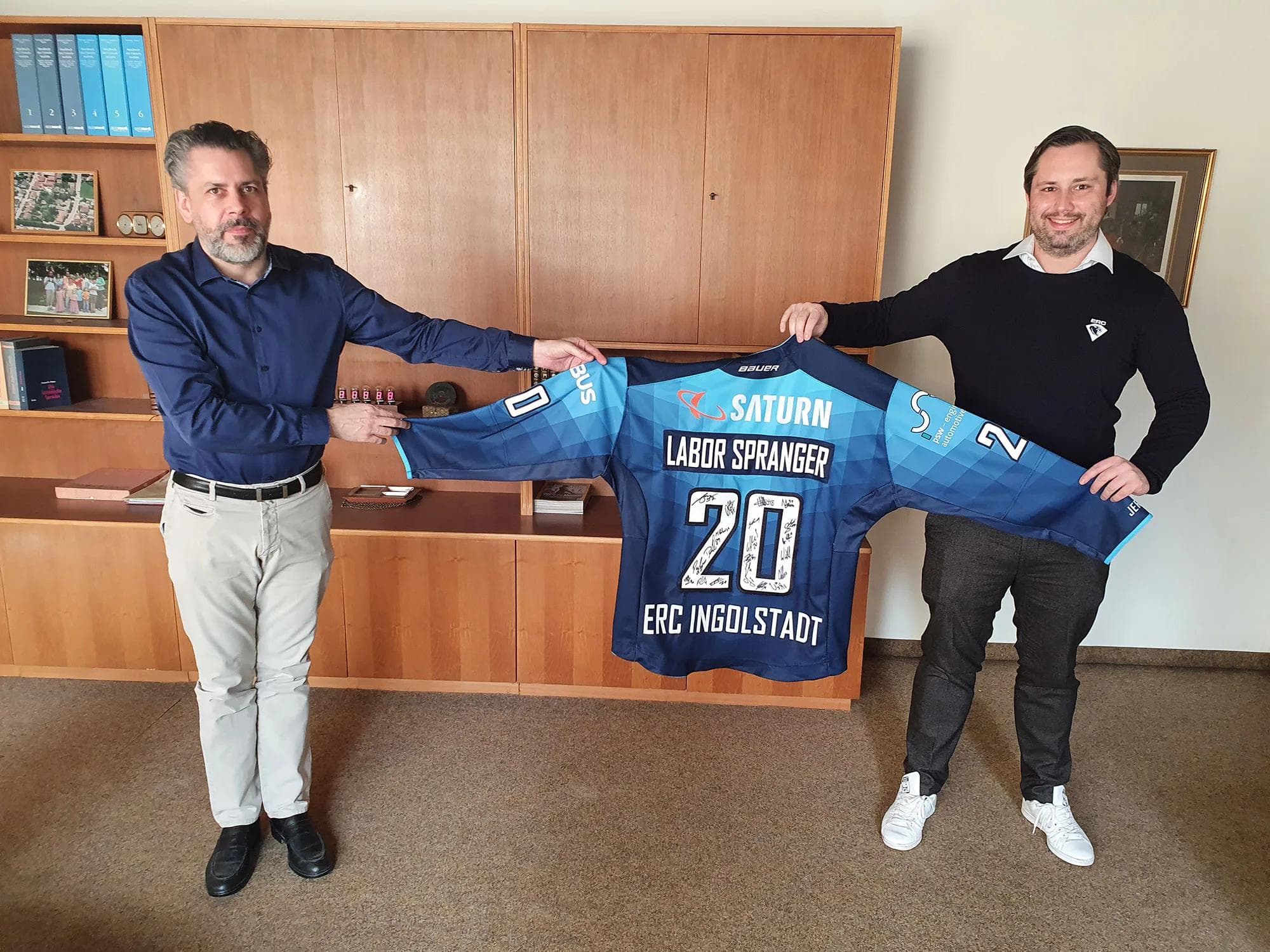 Ein Dankeschön für die große Hilfe: Nicholas Rausch (re.) überreicht Dr. Steffen Spranger ein Trikot mit den Unterschriften des Teams.