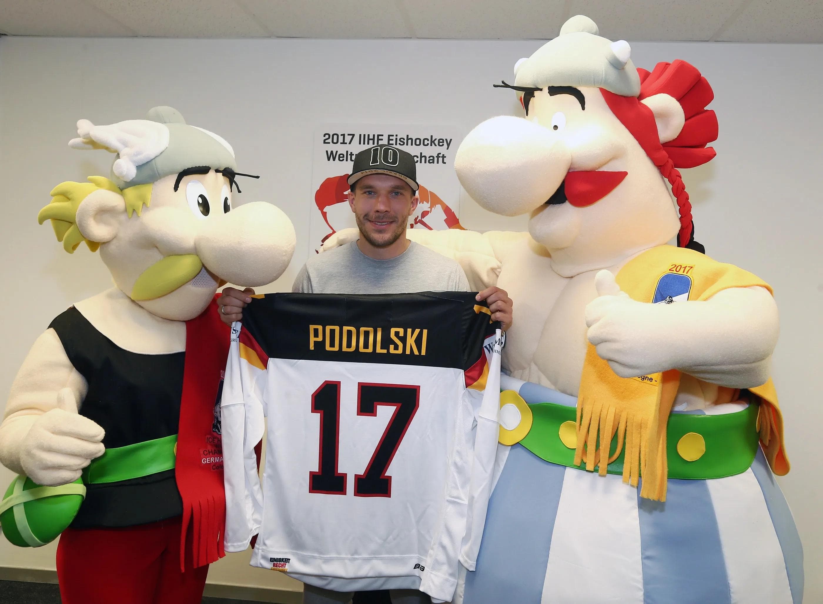 Die WM-Maskottchen Asterix und Obelix überreichten Lukas Podolski ein DEB-Trikot. Foto: Herbert Bucco