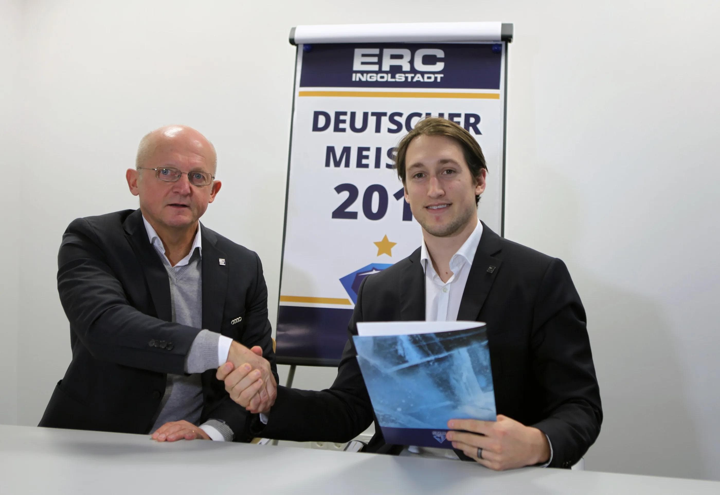 Brandon Buck (rechts) beim Handschlag mit Sportdirektor Jiri Ehrenberger nach der Vertragsverlängerung