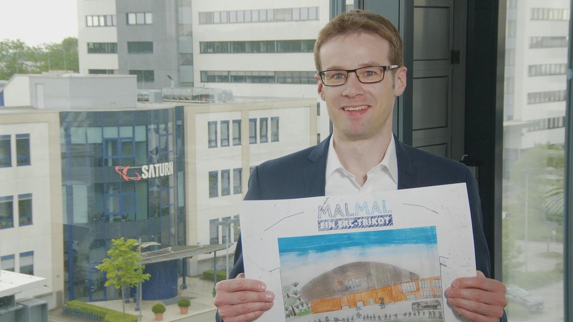 Florian Wieser (CFO MediaMarktSaturn) über das Bild von Kilian (8): "Ich freue mich, dass hier so viele Menschen vor der Saturn-Arena sind - obwohl unser Xaver ein bisschen unheimlich geraten ist."